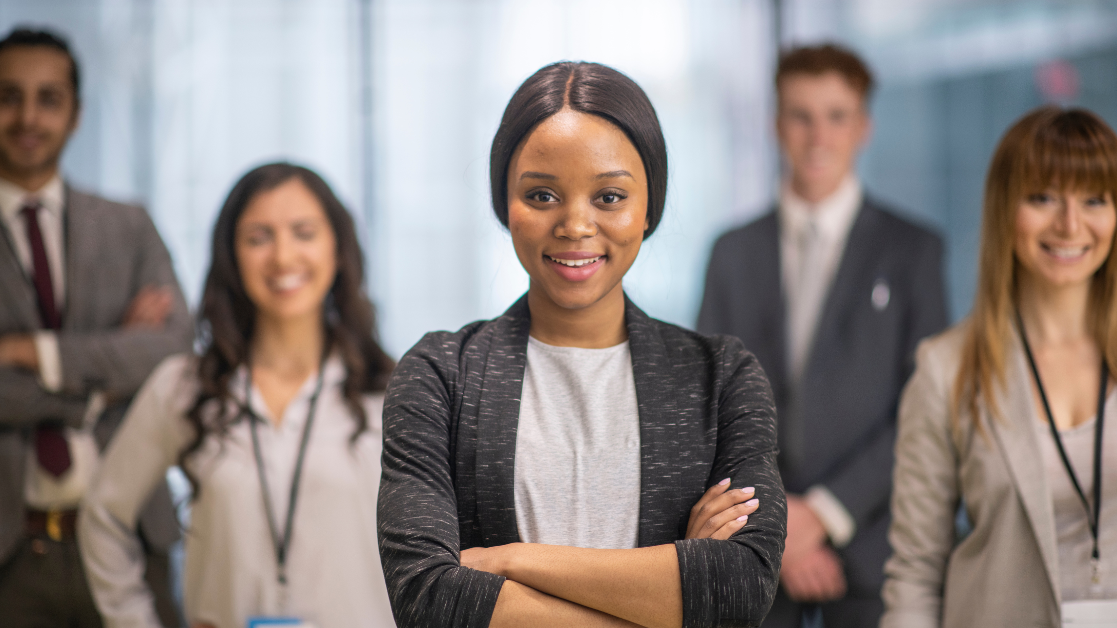 Confident young African-American female leader standing in front, symbolizing diversity in leadership.